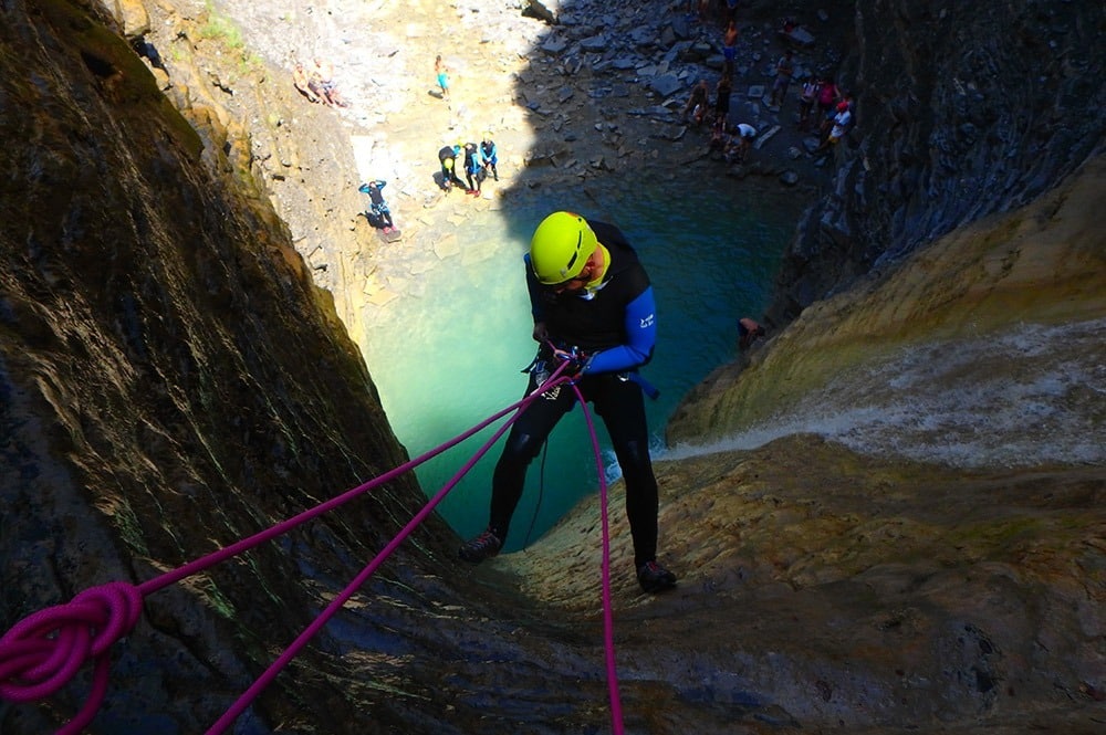 Barranquista descendiendo en rápel hacia la poza del Barranco Os Lucas