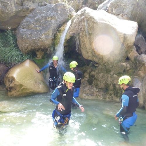 Grupo con casco y neopreno avanzando por el Barranco Os Lucas con guía